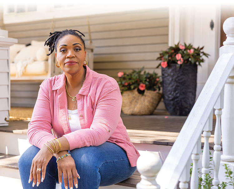 Kelly sits on the front stairs of her house.