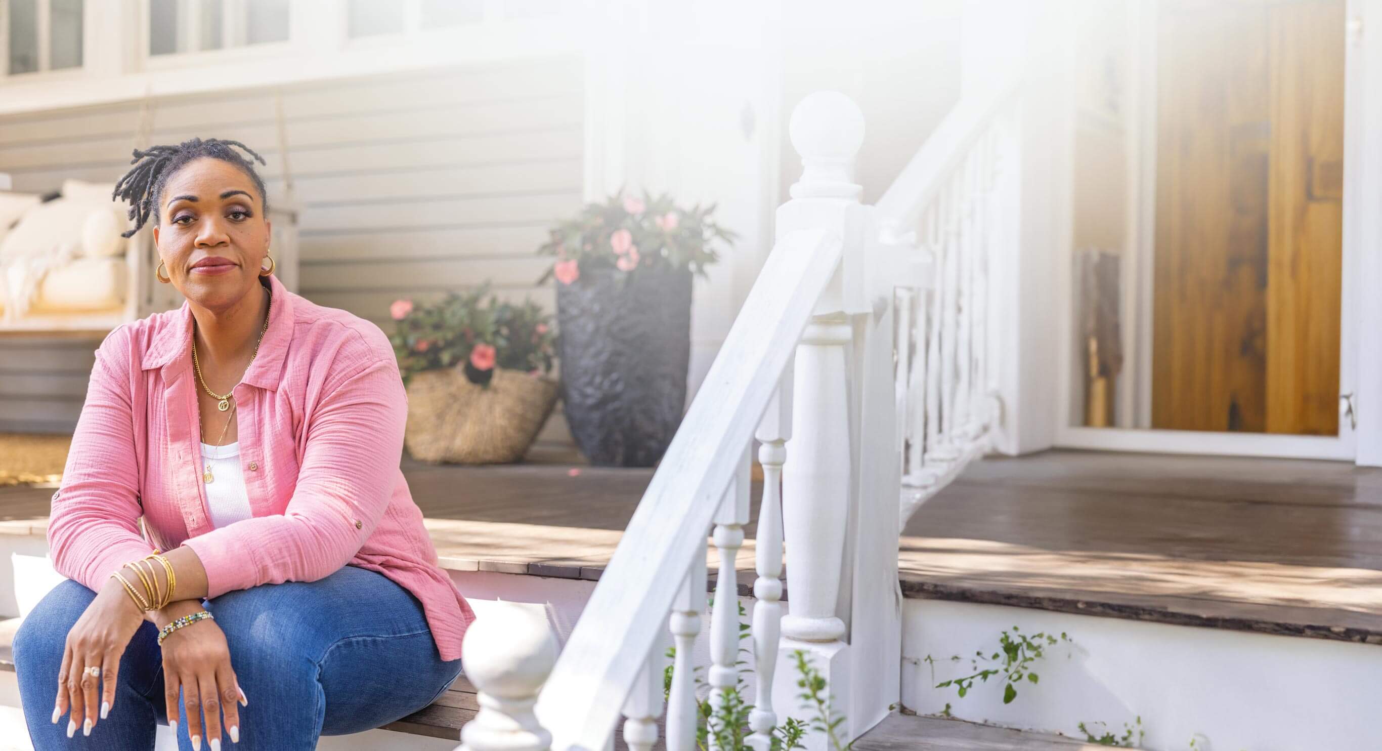 Kelly sits on the front stairs of her house.